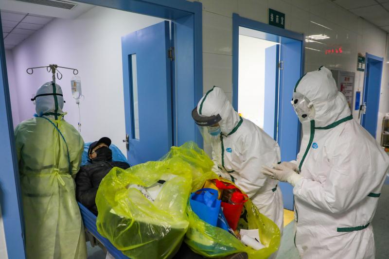 Wuhan'daki belirlenmiş bir hastanenin izole bir koğuşunda yeni bir koronavirüs hastasını taşıyor. reuters.JPG