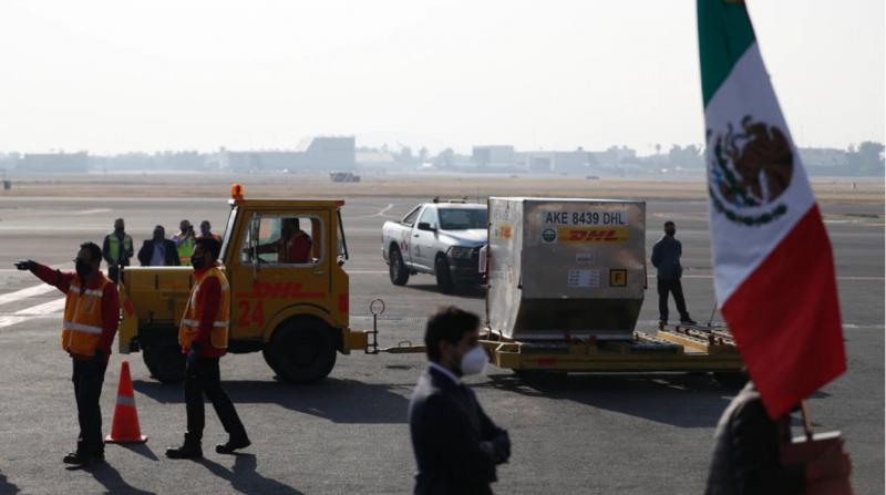 Pfizer COVID-19 aşısının Meksika'ya ilk sevkiyatı, 23 Aralık 2020'de Mexico City'deki Benito Juarez Uluslararası Havaalanı'nda bir DHL kargo uçağından indirildikten sonra asfaltta taşınıyor.jpg