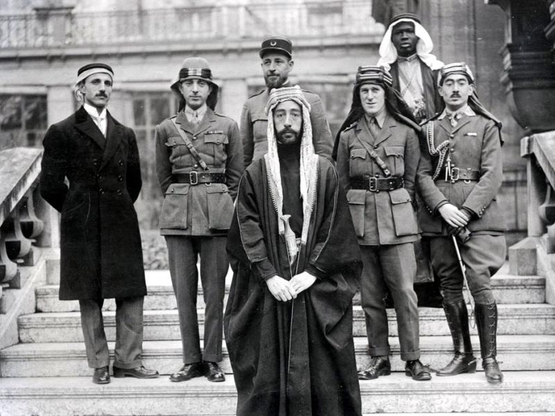 Nuri Said Paşa (soldan ikinci), Irak Kralı I. Faysal ve İngiliz ajanı Lawrence ile birlikte saray aile fotoğrafı.jpg