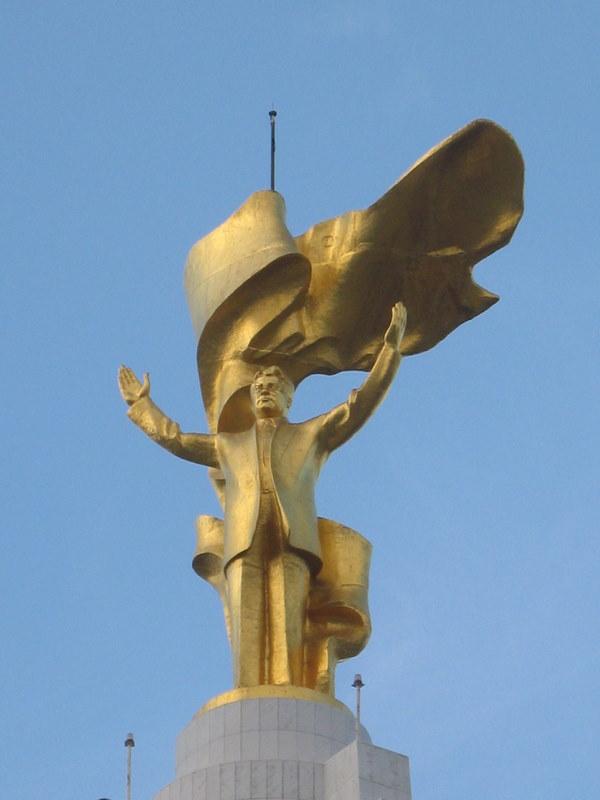 Aşkabat'taki Tarafsızlık Anıtı'nın tepesinde, her zaman güneşe dönük olarak dönen Niyazov'un altın heykeli.jpg