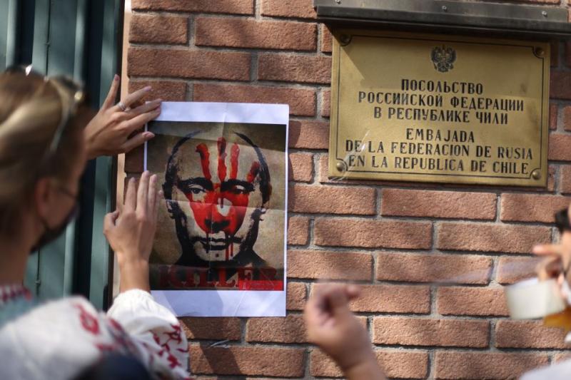 Göstericiler, Rusya'nın 24 Şubat 2022'de Santiago Şili'de Ukrayna'ya karşı büyük bir askeri operasyon başlatmasının ardından Rus büyükelçiliği önündeki savaş karşıtı protesto sırasında Vladimir Putin'in bReuters.jpg