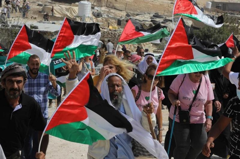 Batı Şeria'da Yahudi yerleşimcilerin yakıp yıktığı Filistin El Mufaqqara Köyü için dayanışma yürüyüşüne katılan Filistinliler ile İsrailli barış.jpg