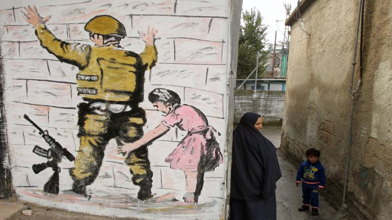 Kontrol noktalarından bezmiş insanların hayali, Beytlehm duvar resmine yansımış. Filistinli küçük kız, İsrail askerinin üstbaşını arıyor. Fotoğr.jpg