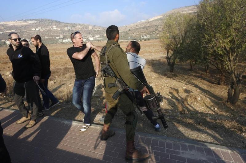 Nablus yöresinde İsrail askerinden destek alan bir Yahudi yerleşimci,  bir Filistinliye saldırıyor. Kaynak-Filistin VEFA ajansı.jpg