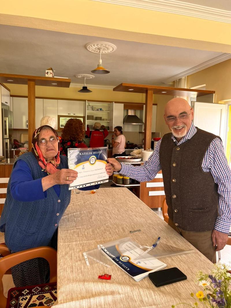 Dr. Fikret, meditasyon ve terapi seansına katılan ablası Asiye Hanım'a katılım belgesi veriyor_.jpg