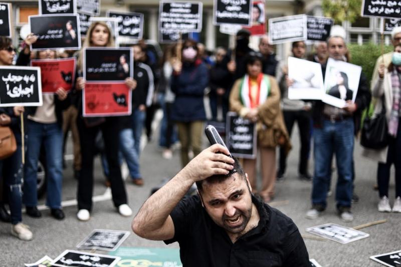 Mehsa J. Emini'nin katlini protesto için İranlı bir erkek saçını tıraş ediyor,Brüksel. Görsel-AFP.jpg
