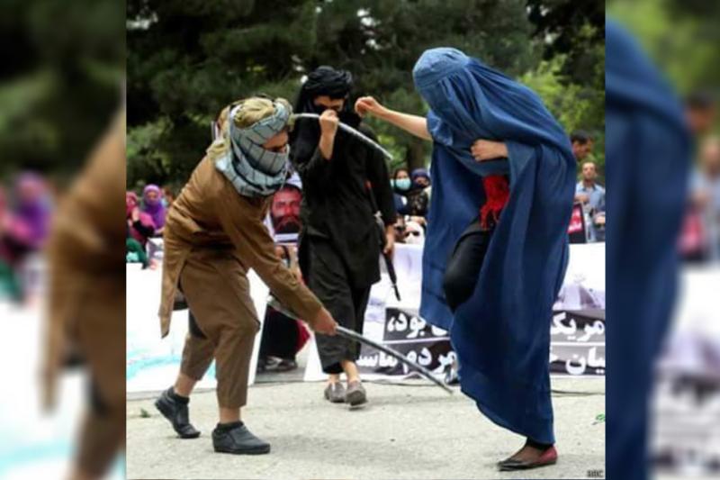 Taliban askeri topukları görünen kadının ayaklarını kırbaçlıyor.jpg