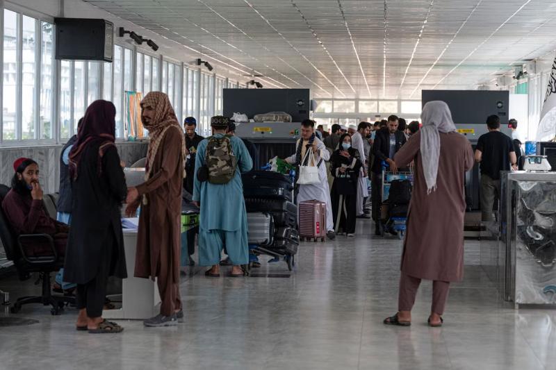 Yolcular, Ağustos'ta Kabil Havalimanı'ndaki bir güvenlik kontrol noktasından geçerken (AFP)