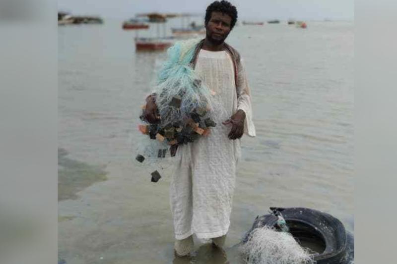 Sudanlı balıkçı Bay Ali, balık tutma gezisine hazırlık amacıyla ağlarını taşıyor Hasan Hamid – Independent Arabia.jpg