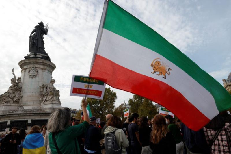 Paris'teki göstericiler, Mahsa Amini'nin ölümünün ardından İran'da düzenlenen gösterileri desteklemek için 1979 devrimi öncesindeki İran bayraklarını sallıyor, 29 Ekim 2022 .jpg