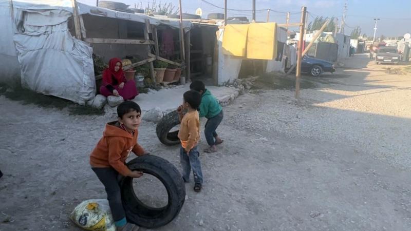 Beyrut'un kuzeydoğusundaki Bekaa Vadisi'nde bulunan Tel Vezze mülteci kampında lastiklerle oynayan Suriyeli mülteci çocuklar.jpg