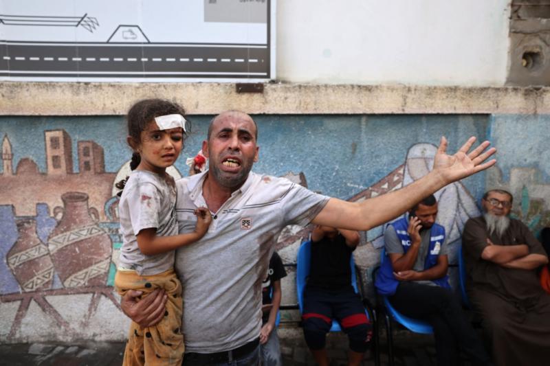 İsrail bombardımanından yaralanan kız, babasının kucağında, 17 Ekim El Mecelle.jpg