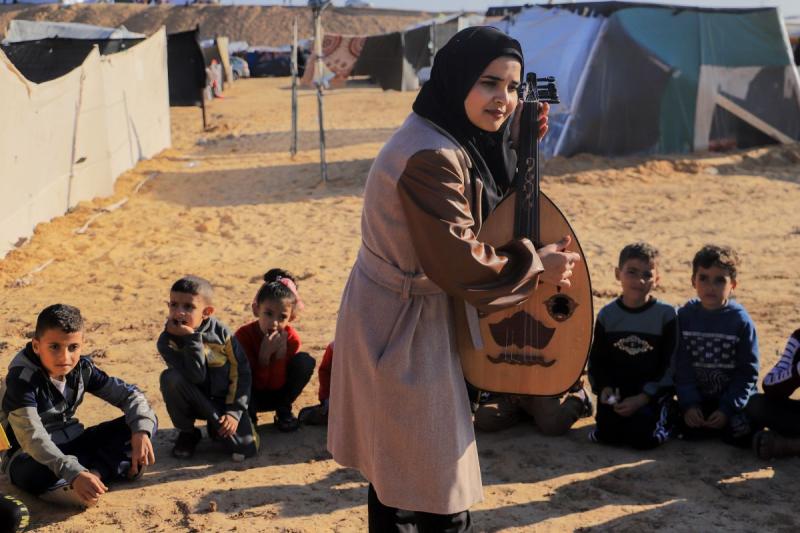 Müzik karşısında çocuklar Gazze'de etraflarındaki patlama seslerini umursamıyor.jpg
