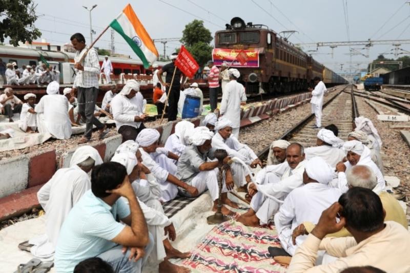 Çiftçiler, Hindistan'ın Haryana eyaletinin kuzeyindeki Sonipat'ta ülke çapındaki protestolar sırasında tarım yasalarına karşı protestoların bir parçası olarak demiryolu hatlarını kapattı, 27 Eylül 2021.jpg