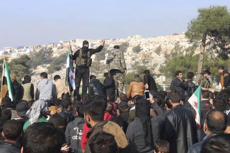 Heyetu Tahriru'ş Şam üyeleri, Aralık 2019'da Bab el-Hava Sınır Kapısı yakınlarında, bölgelerine yönelik devam eden saldırıları protesto eden göstericilerle karşı karşıya geldi AP.jpg