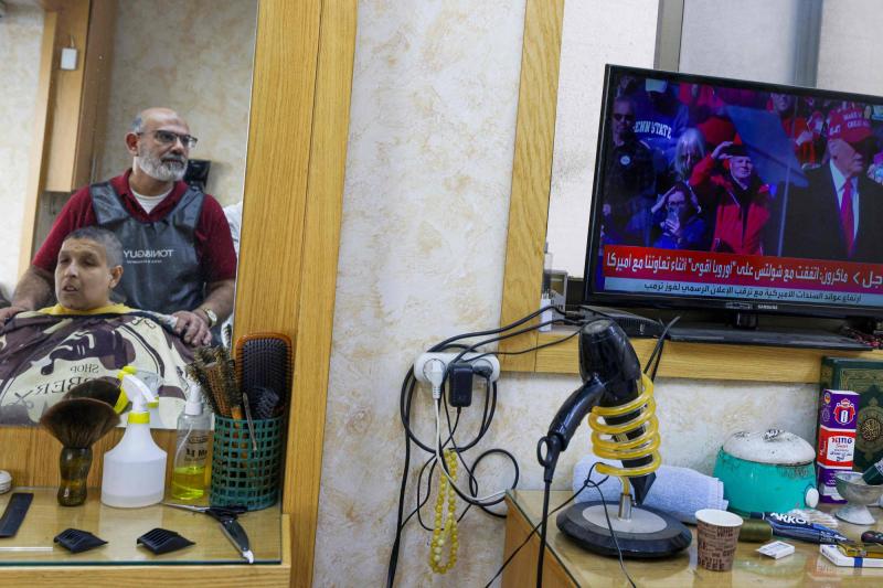 Ramallah'ta bir berber dükkanında Trump'ın seçim zaferi haberini izleyen iki Filistinli / Fotoğraf: AFP