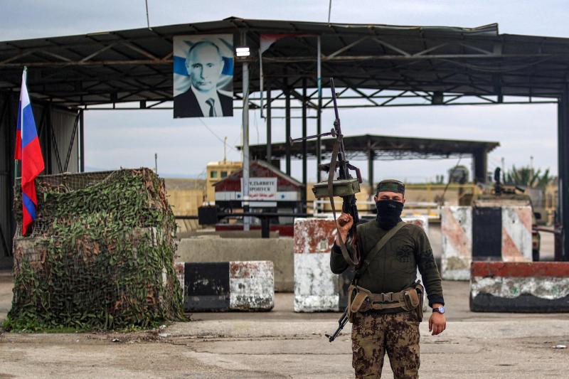 Lazkiye'de Rusya'nın kullandığı Hmeymim Askeri Üssü'nün girişindeki araç kontrol noktasında görevli Suriyeli muhalif grupların bir üyesi, 29 Aralık 2024 / Fotoğraf: AFP