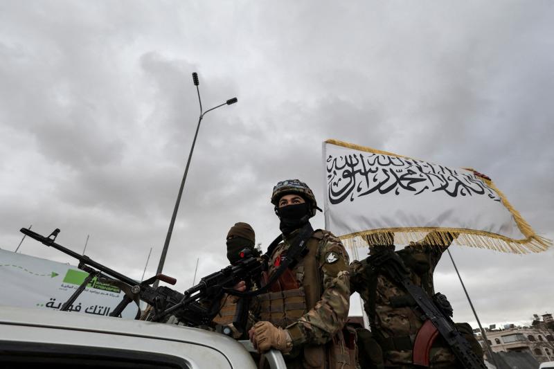 HTŞ'nin Şam'daki askeri geçit töreninde yer alan maskeli savaşçılar / Fotoğraf: Reuters