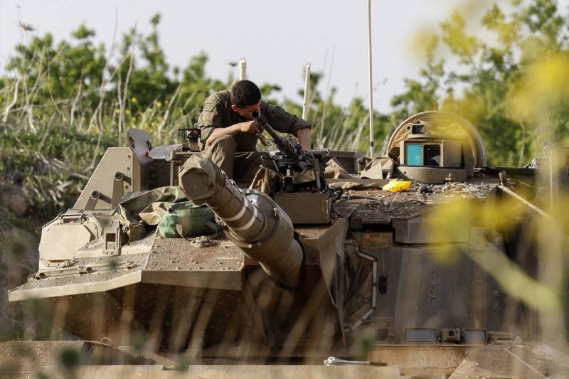Suriye'nin güney sınırı boyunca İsrail tarafından ilhak edilen Golan Tepeleri'ndeki bir bölgede bir Merkava savaş tankını inceleyen bir İsrail askeri, 25 Mart 2025 / Fotoğraf: AFP
