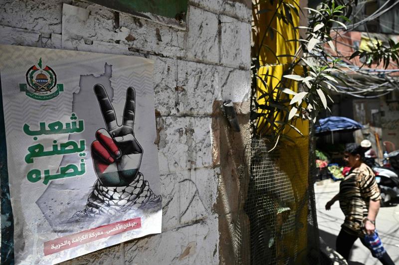 Beyrut'un güney banliyölerinde bulunan Burc el-Baracne Mülteci Kampı'ndaki bir sokakta "Halk zaferini kazanıyor" sloganı / Fotoğraf: AFP