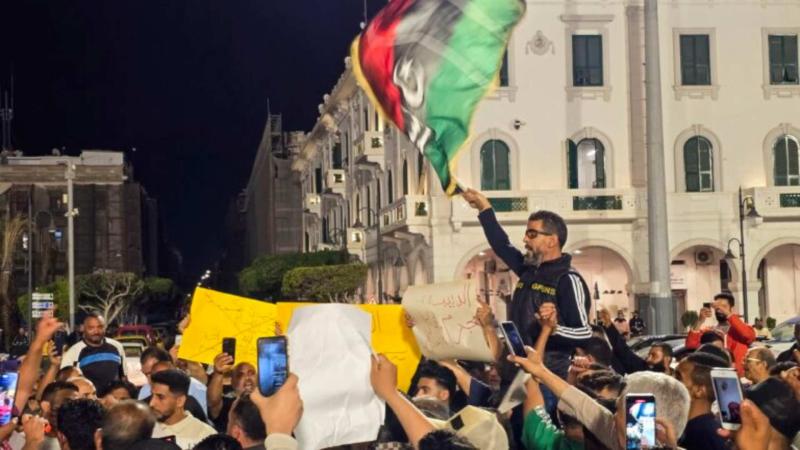 Trablus'un Şehitler Meydanı'nda UBH’nin istifası talebiyle düzenlenen bir gösteri sırasında Libya bayrakları ve pankartlar taşıyan protestocular, 17 Mayıs 2025 / Fotoğraf: AFP