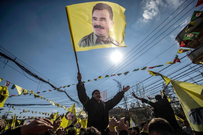 Suriye'nin Kamışlı kentinde PKK lideri Abdullah Öcalan'ın serbest bırakılmasını talep eden bir gösteri sırasında bir protestocu üzerinde Öcalan'ın resmi bulunan bir bayrağı sallarken, 15 Şubat 2025 / Fotoğraf: AFP