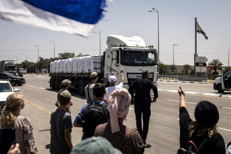 İsrailli göstericiler, 21 Mayıs’ta Kerem Şalom sınır kapısında Gazze’ye yönelik insani yardım girişini engellemek amacıyla düzenledikleri protesto sırasında yoldan geçen bir kamyonu işaret ediyor / Fotoğraf: John Wessels-AFP