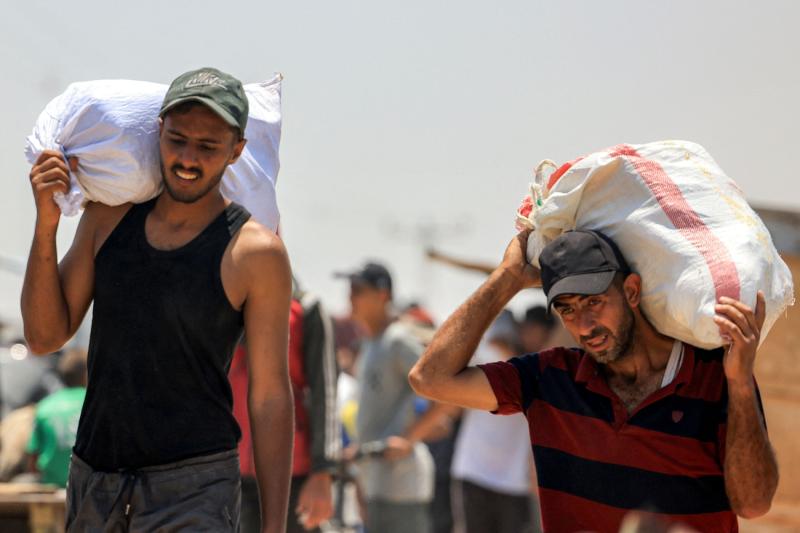 Gazze Şeridi'nin güneyindeki Refah'ta ABD destekli bir kuruluşun verdiği yardımı  taşıyan yerlerinden edilmiş Filistinliler, 10 Haziran 2025 / Fotoğraf: AFP