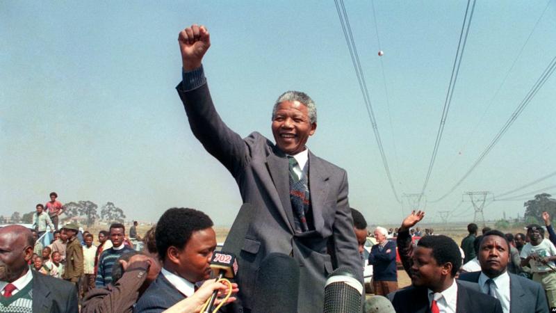 Apartheid karşıtı lider ve Afrika Ulusal Kongresi (ANC) üyesi Nelson Mandela, 5 Eylül 1990'da Tokoza'daki kasaba turu sırasında bir kalabalığa hitap ederken yumruğunu kaldırıyor / Fotoğraf: AFP