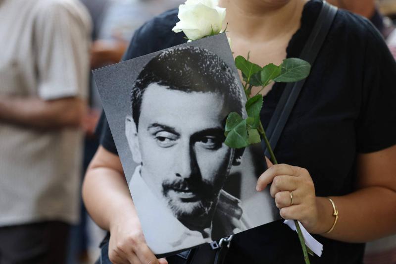 Elinde bir gül ve Ziyad Rahbani'nin fotoğrafını tutan bir Lübnanlı / Fotoğraf: AFP