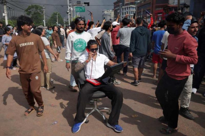Sosyal medya platformlarına yeniden erişilebilen ülkedeki bir eylemci parlamentodan yağmalanan telefon ve monitörle poz verdi / Fotoğraf: Reuters