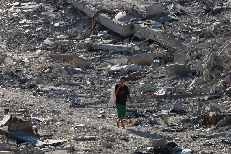 İsrail güçlerinin Gazze Şeridi'nin güneyindeki Han Yunus'tan çekilmesinin ardından enkazın arasında yürüyen bir Filistinli çocuk, 11 Ekim 2025 / Fotoğraf: Reuters