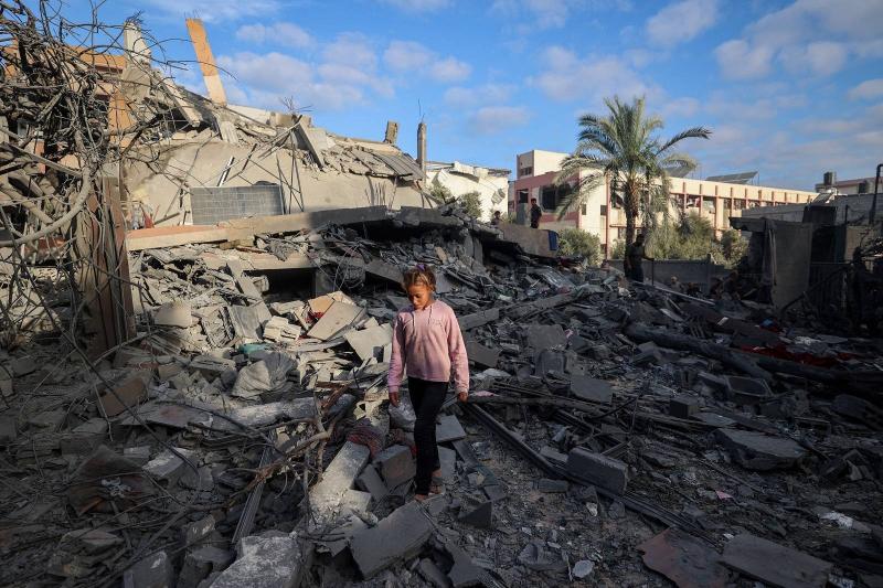 Gazze Şeridi'nin orta kesimindeki Nuseyrat'ta İsrail bombardımanı sonucu yıkılan bir evin enkazı arasında yürüyen bir kız çocuğu / Fotoğraf: AFP