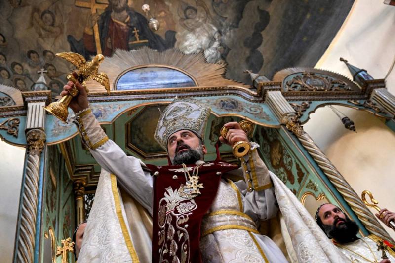 Şam Ermeni Apostolik Kilisesi Piskoposu Armaş Nalbandyan, eski Şam bölgesindeki Bab el-Şarki'de bulunan Aziz Sarkis Kilisesi'nde düzenlenen Noel Ayini'nde su kutsaması sırasında bir güvercin heykelini tutuyor, 6 Ocak 2025 / Fotoğraf: AFP