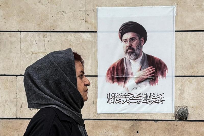 İranlı bir kadın, Washington ile Tahran arasındaki barış görüşmelerinin başarısızlıkla sonuçlanmasının ardından, Tahran'da Mücteba Hamaney'in posterinin yanından geçiyor, 13 Nisan 2026 / Fotoğraf: AFP