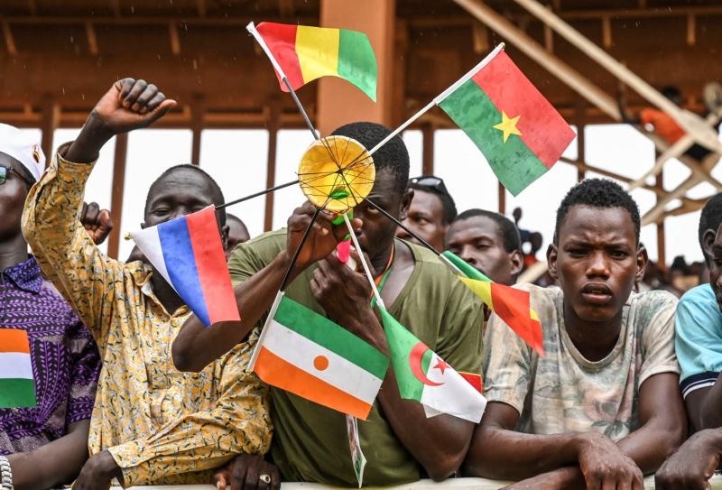 Niamey'deki General Seyni Kountché Stadyumu'nda toplanan Nijer Ulusal Konseyi destekçilerinden biri Mali, Burkina Faso, Cezayir, Nijer ve Rusya bayraklarını taşırken, 26 Ağustos 2023 / Fotoğraf: AFP