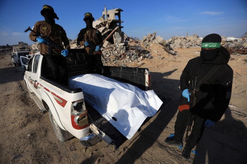 İslami Cihad ve Hamas hareketlerinden silahlı kişiler, Gazze'nin kuzeyindeki Beyt Lahiye beldesinde İsrailli bir rehineye ait kalıntıları taşırken, 3 Aralık 2025 / Fotoğraf: AFP
