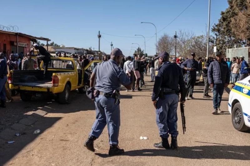 Soweto’nun White City bölgesinde, Operation Dudula hareketinin yabancılara ait dükkânların kapatılması çağrısıyla toplandığı sırada yoğun polis güvenliği dikkat çekiyor / Fotoğraf: AFP