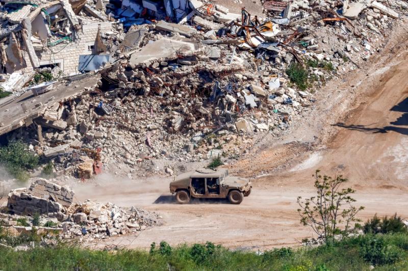 Kuzey İsrail'den, sınırın diğer tarafından görülen bir İsrail Humvee askeri aracı, Güney Lübnan'daki yıkılmış binaların yanından geçiyor, 7 Mayıs 2026 / Fotoğraf: AFP