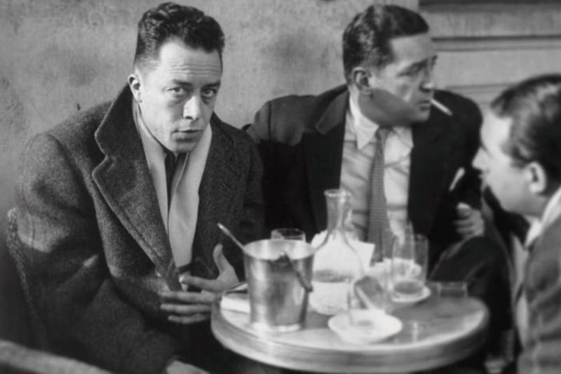 Fransız yazar Albert Camus (solda), arkadaşlarıyla birlikte Paris'in Saint-Germain-des-Prés semtindeki Les Deux Magots kafesinin terasında, 1945 yılında 