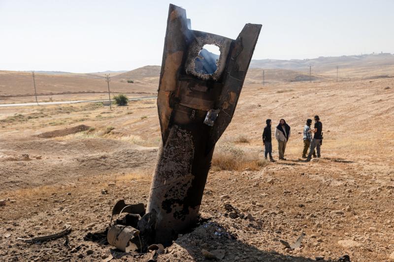 İşgal altındaki Batı Şeria'nın orta kesimlerinde İran'ın gerçekleştirdiği saldırıların ardından bir füzenin parçasının yanında duran İsrailli yerleşimciler, 8 Haziran 2026 / Fotoğraf: Reuters