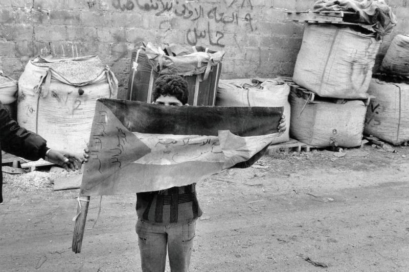 Birinci İntifada (1987-1993) sırasında, yeni kurulan İslami Direniş Hareketi (Hamas) grafitisinin önünde Filistin bayrağı tutan bir çocuk