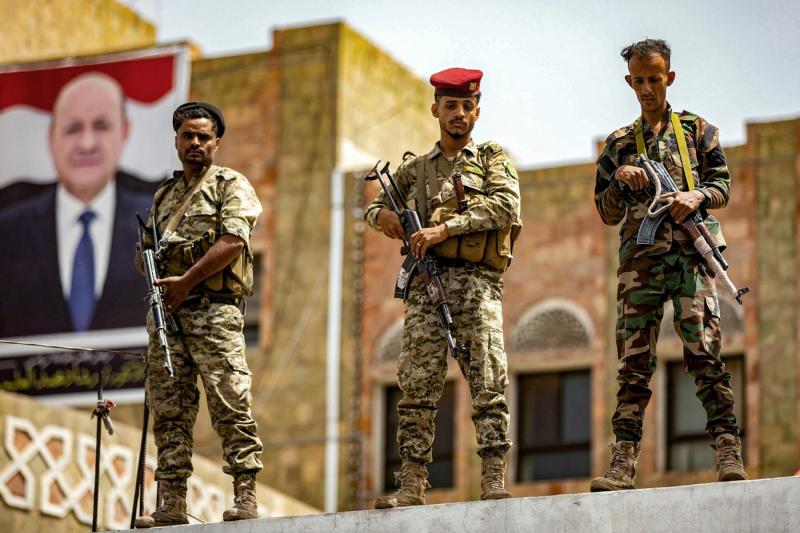 Yemen hükümetine bağlı askerler, Husiler tarafından yıllardır Taiz kentine uygulanan kuşatmanın sona erdirilmesini talep eden protesto gösterisinde Aden'de Cumhurbaşkanlığı Liderlik Konseyi Başkanı Reşad el-Alimi'nin fotoğrafının yer aldığı bir pano önünd