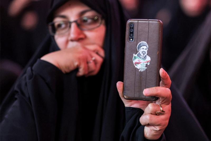 Telefonunun arkasına Mücteba Hamaney resmi yapıştıran İranlı bir kadın / Fotoğraf: AFP