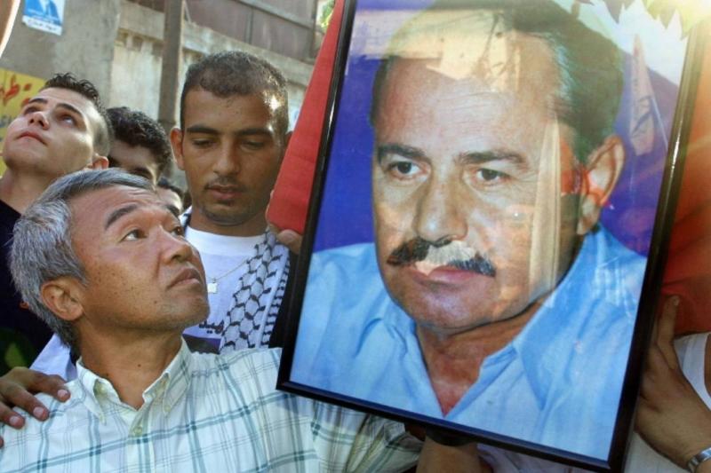 Okamoto, İsrail tarafından katledilen Halk Cephesi lideri Ebu Ali Mustafa'nın posterini taşıyor – Şatilla Mülteci Kampı, Beyrut