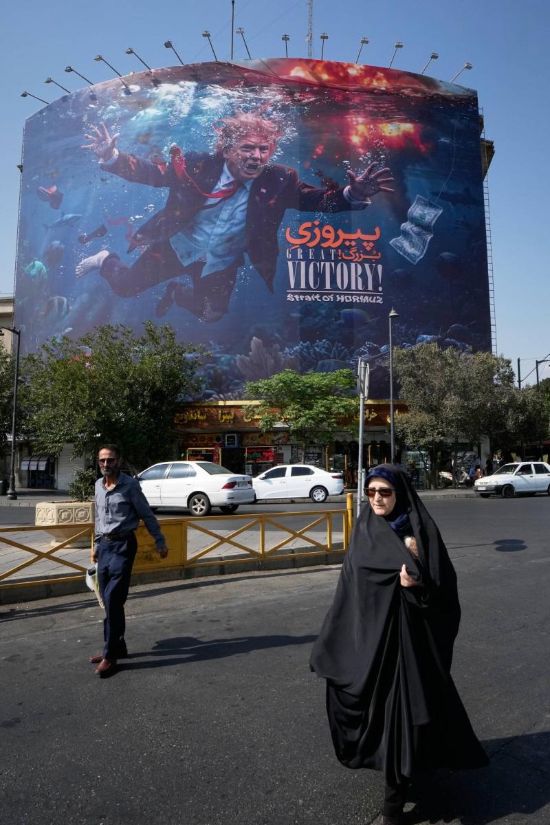 Tahran’ın güneyinde, ABD Başkanı Donald Trump’ın resminin yer aldığı ABD karşıtı bir propaganda afişinin önünden geçen İranlılar, 24 Ağustos 2026 / Fotoğraf: AP