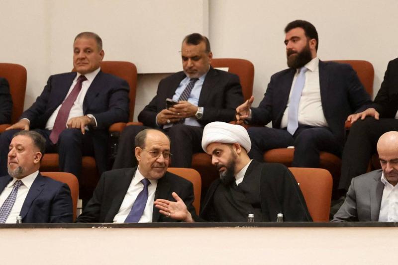 Asaib Ehlil Hak’ın lideri Kays el-Hazali, Bağdat'taki meclis binasında Ali Zeydi başkanlığındaki hükümetin oylaması için yapılan oturum sırasında eski Irak başbakanı Nuri el-Maliki ile konuşuyor, 14 Mayıs 2026 / Fotoğraf: Reuters