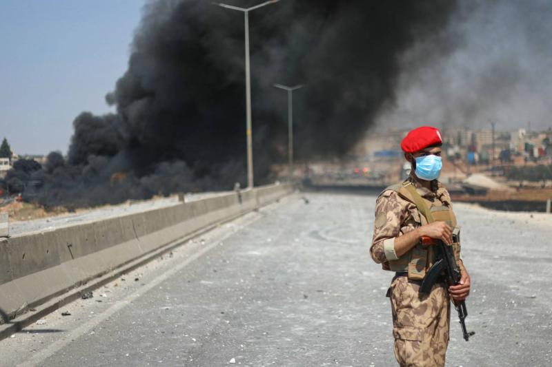 9 Eylül'de İdlib'de 14 kişinin hayatını kaybetmesine neden olan bir silah deposu patlamasının ardından, Suriyeli askerin arkasından yükselen duman / Fotoğraf: AFP