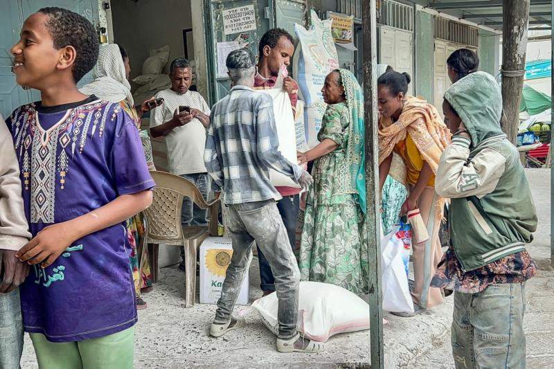 Tigraylı isyancılar ile Etiyopya federal hükümeti arasında yeniden başlayan çatışmalar sırasında, Mekelle'deki yerel bir pazarda un ve diğer gıda ürünlerini satın almak için toplanan sakinler, 24 Eylül 2026 (AFP.jpeg