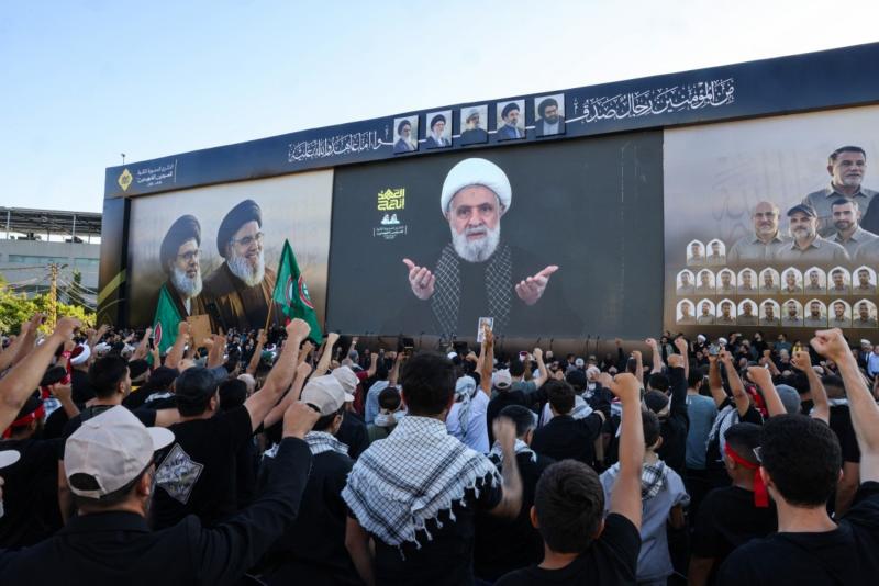Beyrut'un güney banliyösünde, eski lider Hasan Nasrallah'ın suikastının ikinci yıldönümünü anma töreninde, Hizbullah destekçileri liderleri Naim Kasım'ın televizyonda yayınlanan konuşmasını izliyor, 27 Eylül 2026.jpeg